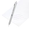Silver mechanical pencil with knurled grip drawing blue, purple, red and gray squiggles on white paper