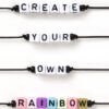 Beads on black cords spell out 'CREATE YOUR OWN RAINBOW' in uppercase letters.