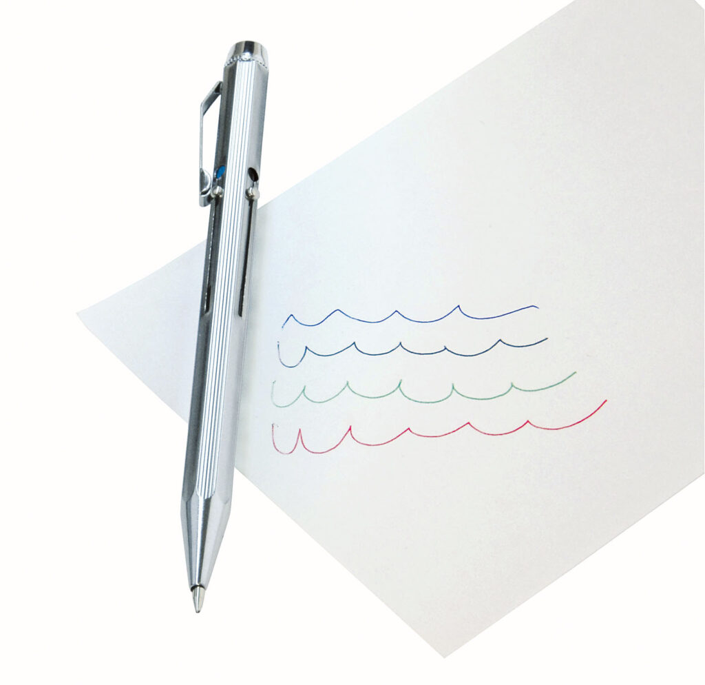 Silver pen clipped to a white sheet of paper with blue, green, and red wavy lines drawn on it